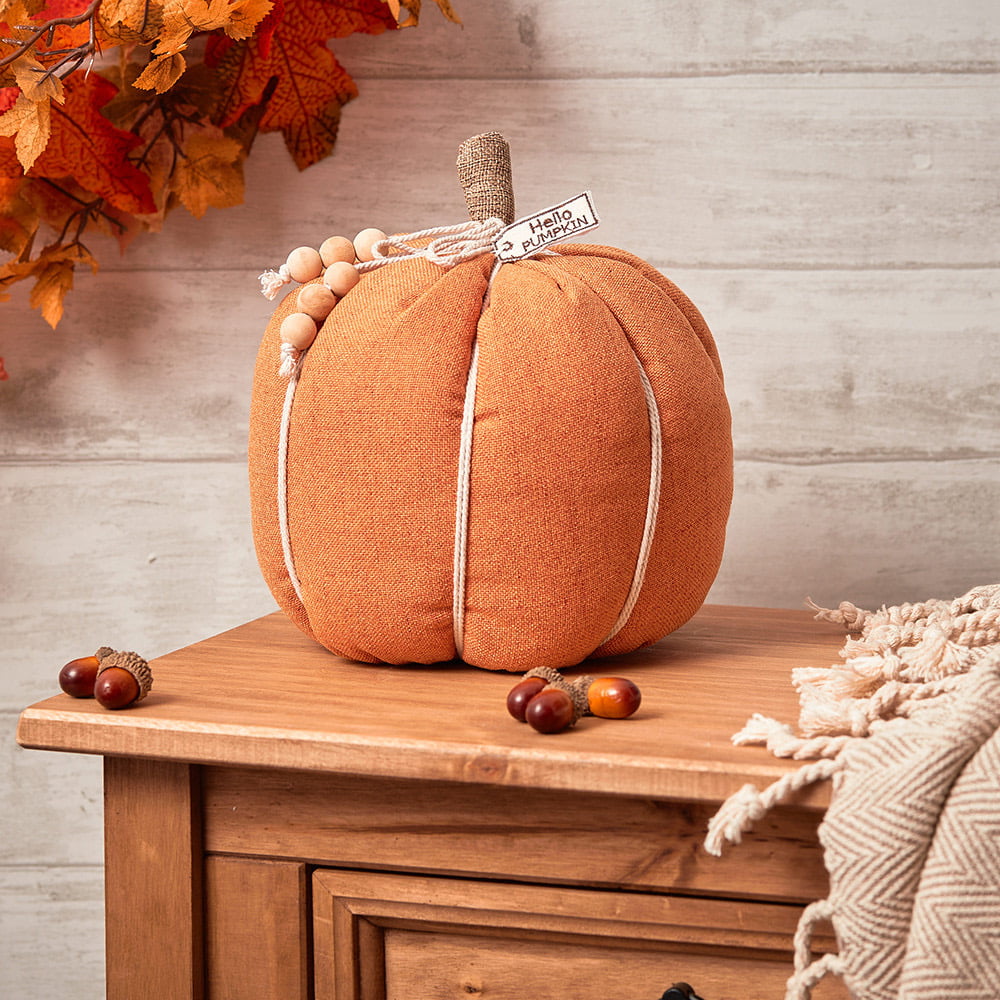A beautiful orange fabric pumpkin with hanging wooden bead detailing. These are weighted doorstops but would definitely look beautiful placed absolutely anywhere
